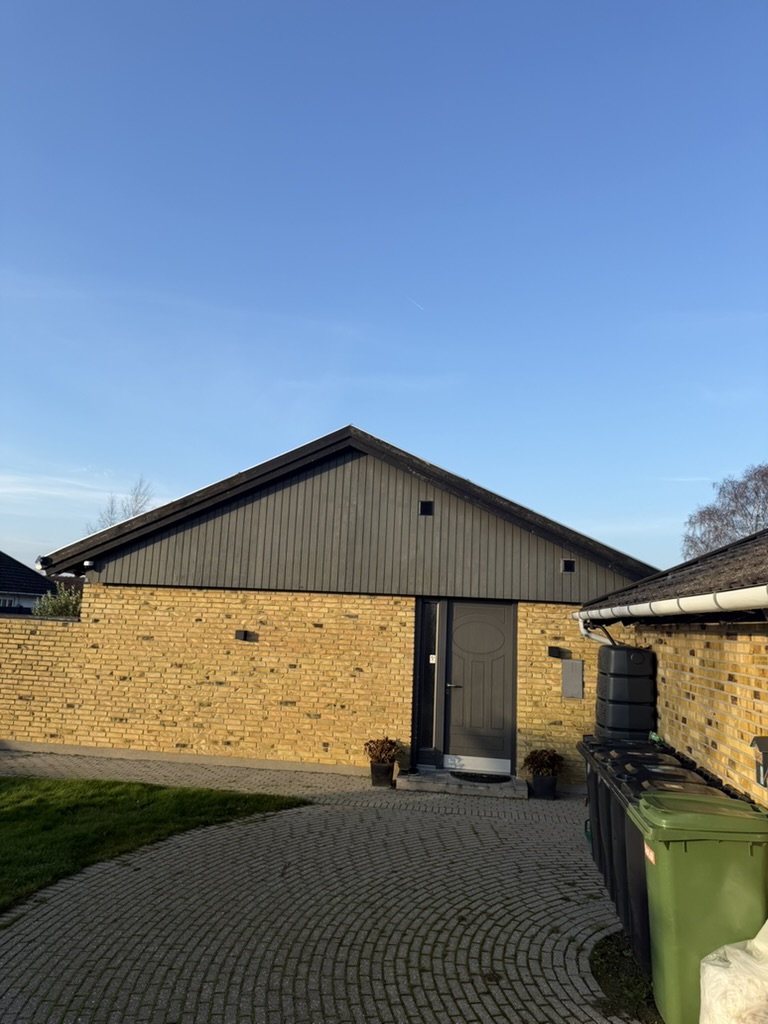 Bungalow med mørke betontagsten og gul murstens-facade