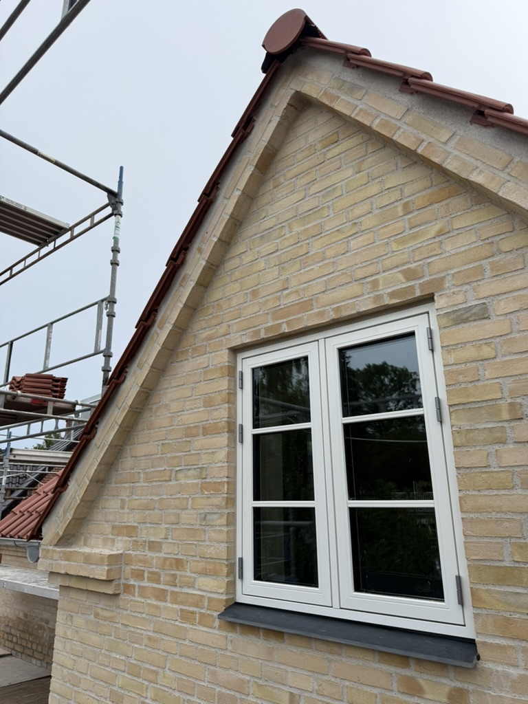 Montering af røde teglsten på gavl med stillads